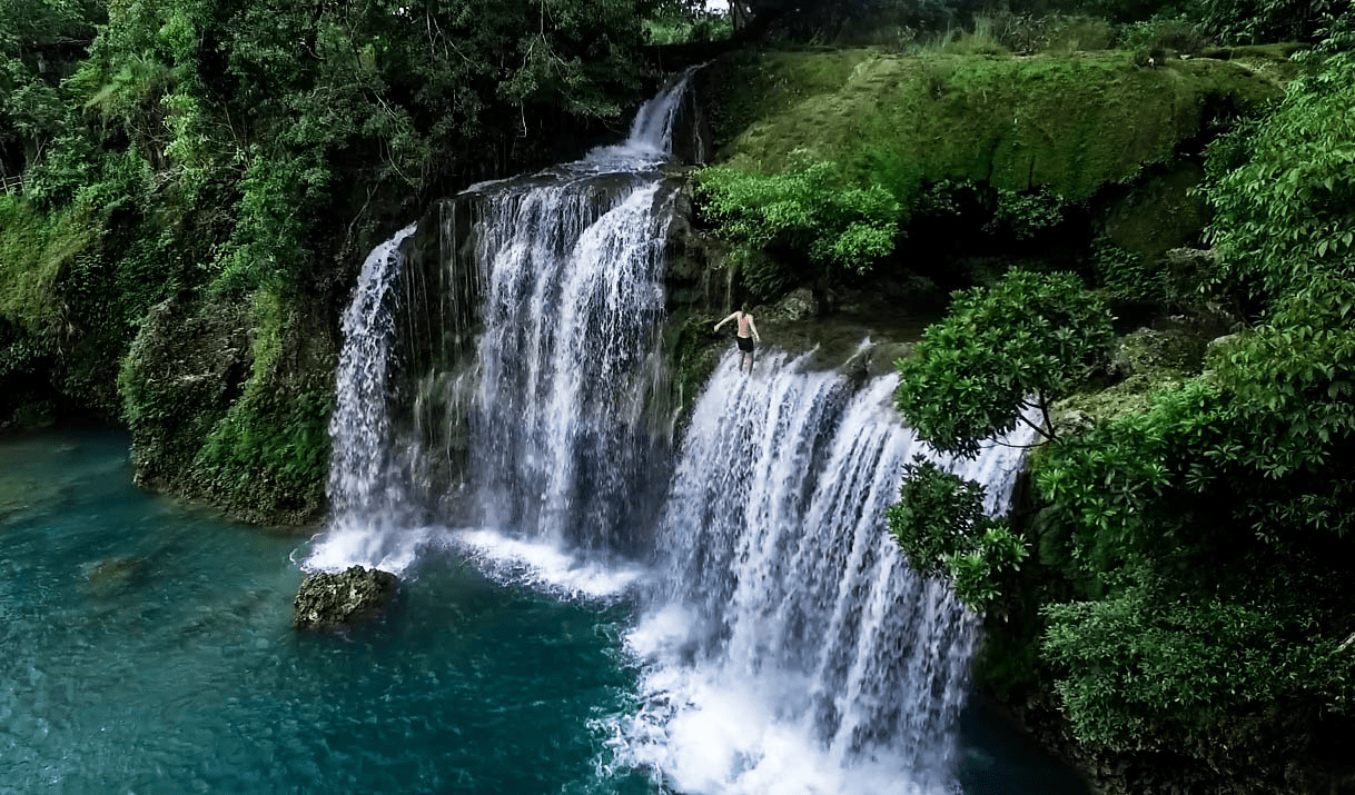 drone photo of lenny through paradise about to jump off the bolinao falls waterfall in pangasinan philippines